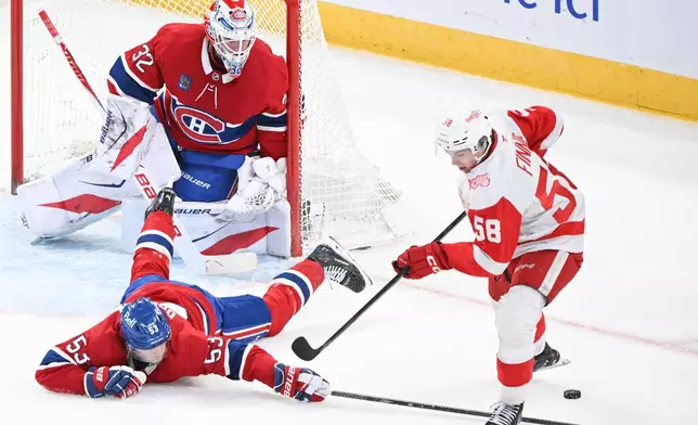 Montreal Canadiens goaltender Jacob Fowler (32) looks on as Canadiens' Noah Dobson (53) blocks a shot by Detroit Red Wings' Emmitt Finnie (58) during third-period NHL hockey game action in Montreal, Saturday, Jan. 10, 2026. (Graham Hughes/The Canadian Press via AP)