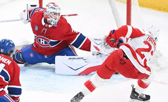 Montreal Canadiens goaltender Jacob Fowler (32) makes a save against Detroit Red Wings' Lucas Raymond (23) during the first period of an NHL hockey game in Montreal, Saturday, Jan. 10, 2026. (Graham Hughes/The Canadian Press via AP)