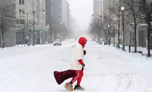 A person crosses a street during a snowstorm, Sunday, Jan. 25, 2026, in Washington. (AP Photo/Julia Demaree Nikhinson)