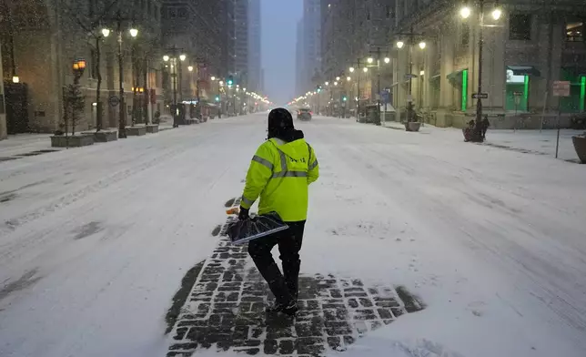 A worker shovels snow during a winter storm in Philadelphia, Sunday, Jan. 25, 2026. (AP Photo/Matt Rourke)