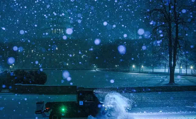 A plow clears snow in front of the U.S. Capitol, Sunday, Jan. 25, 2026, in Washington. (AP Photo/Julia Demaree Nikhinson)