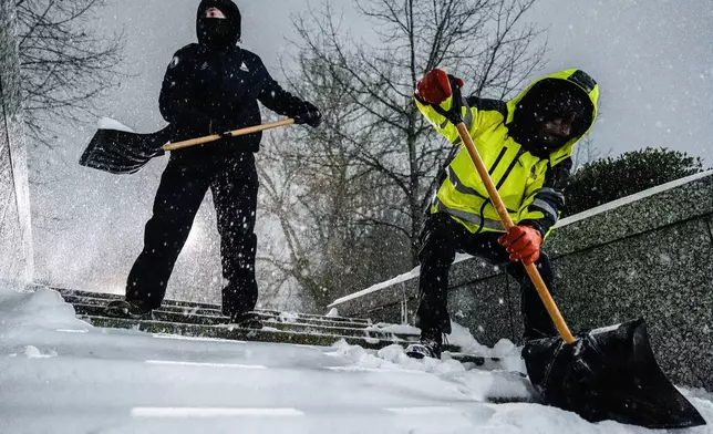 Workers with Architect of the Capitol shovel snow near the U.S. Capitol, Sunday, Jan. 25, 2026, in Washington. (AP Photo/Julia Demaree Nikhinson)