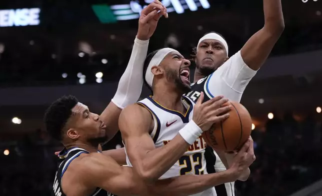 Denver Nuggets' Zeke Nnaji looks to shoot past Milwaukee Bucks' Giannis Antetokounmpo and Myles Turner during the first half of an NBA basketball game Friday, Jan. 23, 2026, in Milwaukee. (AP Photo/Morry Gash)