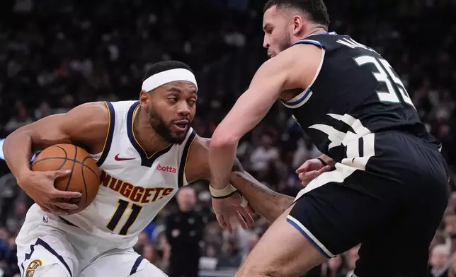 Denver Nuggets' Bruce Brown tries to get past Milwaukee Bucks' Pete Nance during the first half of an NBA basketball game Friday, Jan. 23, 2026, in Milwaukee. (AP Photo/Morry Gash)
