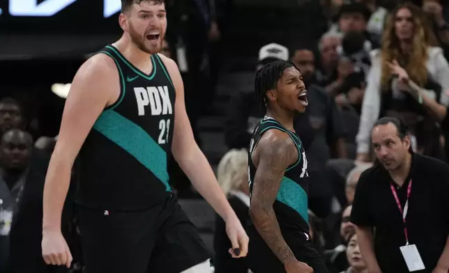 Portland Trail Blazers guard Caleb Love, right, and center Donovan Clingan, left, react to a play during the second half of an NBA basketball game against the San Antonio Spurs in San Antonio, Saturday, Jan. 3, 2026. (AP Photo/Eric Gay)