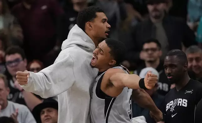 San Antonio Spurs forward Victor Wembanyama, left, and forward Keldon Johnson (3) chest bump during the first half of an NBA basketball game against the Portland Trail Blazers in San Antonio, Saturday, Jan. 3, 2026. (AP Photo/Eric Gay)