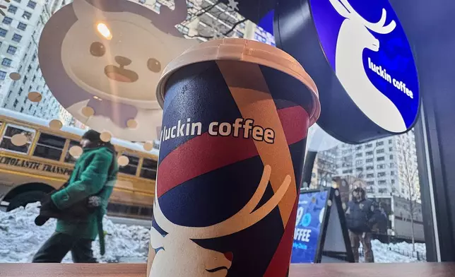 Signage displays in the window and a cup sits on the counter of a Luckin Coffee store in New York, Friday, Jan. 30, 2026. (AP Photo/Richard Drew)