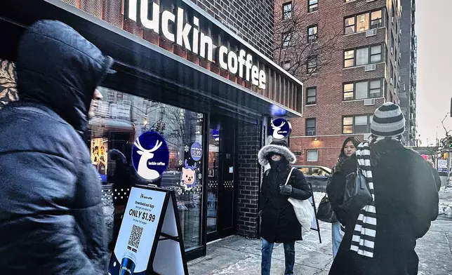 Pedestrians pass a Luckin Coffee store in New York, Friday, Jan. 30, 2026. (AP Photo/Richard Drew)