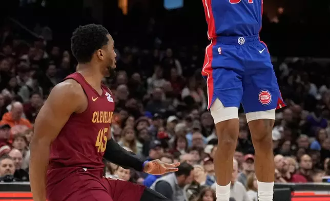 Detroit Pistons guard Daniss Jenkins (24) shoots over Cleveland Cavaliers guard Donovan Mitchell, left, in the second half of an NBA basketball game Sunday, Jan. 4, 2026, in Cleveland. (AP Photo/Sue Ogrocki)