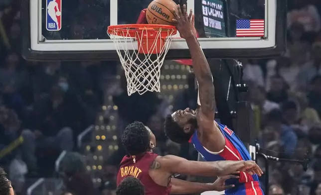 Detroit Pistons forward Paul Reed, right, dunks in front of Cleveland Cavaliers center Thomas Bryant, left, in the first half of an NBA basketball game Sunday, Jan. 4, 2026, in Cleveland. (AP Photo/Sue Ogrocki)