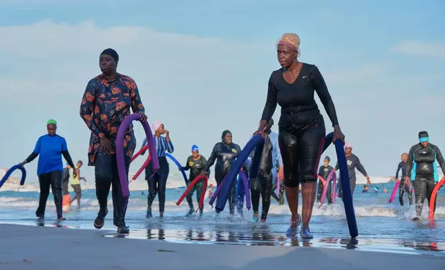 Participants walk out of the ocean after a group aquatic therapy session in Dakar, Senegal, Saturday, Dec. 13, 2025. (AP Photo/Misper Apawu)