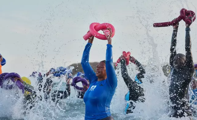 People take part in a group aquatic therapy session in the ocean in Dakar, Senegal, Saturday, Dec. 13, 2025. (AP Photo/Misper Apawu)