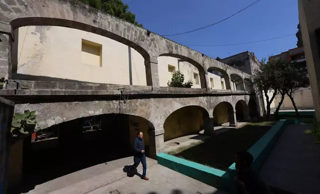 A man walks out of the archway of a cloister that was part of Santo Domingo church, now a residential housing complex in Mexico City, Tuesday, Jan. 27, 2026. (AP Photo/Ginnette Riquelme)