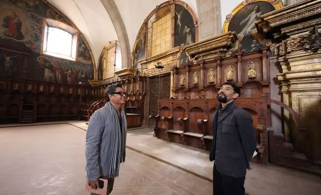 Architect Jesus Martínez, left, and art historian Alejandro Hernandez stand inside the restored choir area of Santo Domingo church in Mexico City, Tuesday, Jan. 27, 2026. (AP Photo/Ginnette Riquelme)
