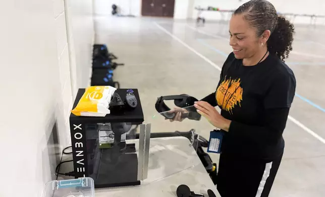 Sabra Williams, Co-Founder of Creative Acts, cleans virtual reality headsets inside Valley State Prison in Chowchilla, Calif., Dec. 11, 2025. (AP Photo/Haven Daley)