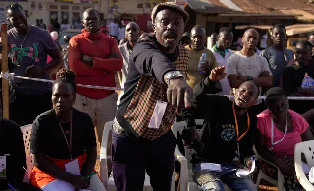 A political representative speaks as he works to observe and verify the counting of ballots after polls closed in the presidential election at a polling station in Kampala, Uganda, Thursday, Jan. 15, 2026. (AP Photo/Brian Inganga)