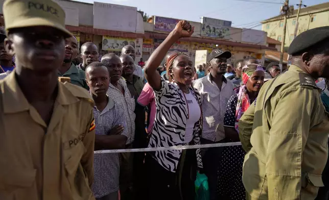 A supporter of leading opposition candidate Bobi Wine cheers while watching election officials count ballots, after polls closed at a polling station in Kampala, Uganda, Thursday, Jan. 15, 2026. (AP Photo/Brian Inganga)