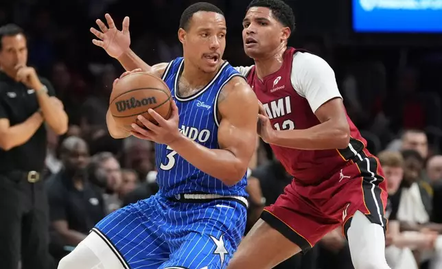 Orlando Magic guard Desmond Bane (3) looks to pass the ball as Miami Heat guard Dru Smith (12) defends during the second half of an NBA basketball game Wednesday, Jan. 28, 2026, in Miami. (AP Photo/Marta Lavandier)