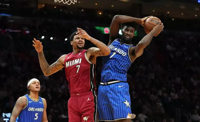 Orlando Magic forward Jonathan Isaac (1) grabs a rebound after Miami Heat center Kel'el Ware (7) missed the basket during the second half of an NBA basketball game Wednesday, Jan. 28, 2026, in Miami. (AP Photo/Marta Lavandier)