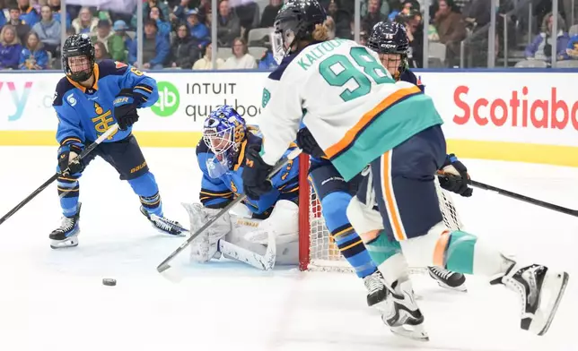 New York Sirens' Kristyna Kaltounkova, front, brings the puck around the net to shoot at Toronto Sceptres goaltender Elaine Chuli, second left, during the first period of an PWHL hockey game in Toronto, Tuesday, Jan. 6, 2026. (Chris Young/The Canadian Press via AP)