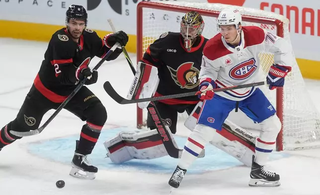 Montreal Canadiens centre Jake Evans (71) tries to tip the puck past Ottawa Senators goaltender Leevi Merilainen (1) as he is pressured by Senators defenceman Artem Zub (2) during the first period of an NHL game, in Ottawa, Saturday, Jan. 17, 2026. (Adrian Wyld/The Canadian Press via AP)