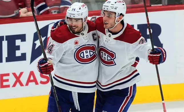 Montreal Canadiens left wing Juraj Slafkovsky (20) celebrates his goal with teammate Nick Suzuki (14) during third period NHL action against the Ottawa Senators in Ottawa, Saturday, Jan. 17, 2026. (Adrian Wyld/The Canadian Press via AP)