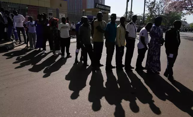 Voters line up to cast their ballots during the presidential election at a polling station in the capital, Kampala, Uganda, Thursday, Jan. 15, 2026. (AP Photo/Brian Inganga)