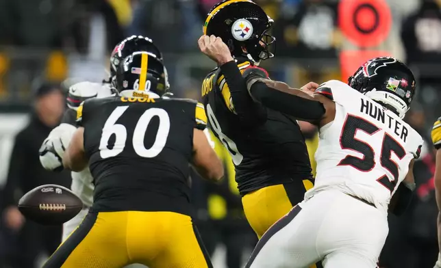 Pittsburgh Steelers quarterback Aaron Rodgers (8) loses possession of the ball while being tackled by Houston Texans defensive end Danielle Hunter (55) during the second half of an NFL wild-card playoff football game, Monday, Jan. 12, 2026, in Pittsburgh. (AP Photo/Gene J. Puskar)
