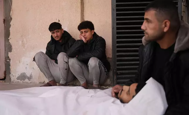 Palestinians mourn over the body of Waleed Darweesh, 20, who was killed in an Israeli strike, during his funeral at Al-Aqsa Hospital in Deir al-Balah, central Gaza Strip, Friday, Jan. 30, 2026. (AP Photo/Abdel Kareem Hana)