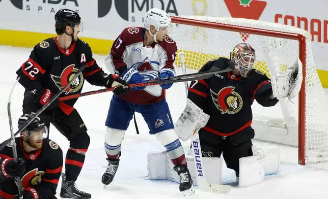 Ottawa Senators goaltender James Reimer (47) makes a save while Colorado Avalanche's Parker Kelly (17) and Senators' Thomas Chabot (72) look on during third period NHL hockey action in Ottawa on Wednesday, Jan. 28, 2026. (Patrick Doyle/The Canadian Press via AP)