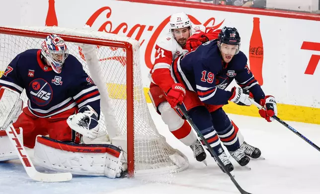 Winnipeg Jets' Jonathan Toews (19) defends against Detroit Red Wings' Dylan Larkin (71) during first-period NHL hockey game action in Winnipeg, Manitoba, Saturday, Jan. 24, 2026. (John Woods/The Canadian Press via AP)