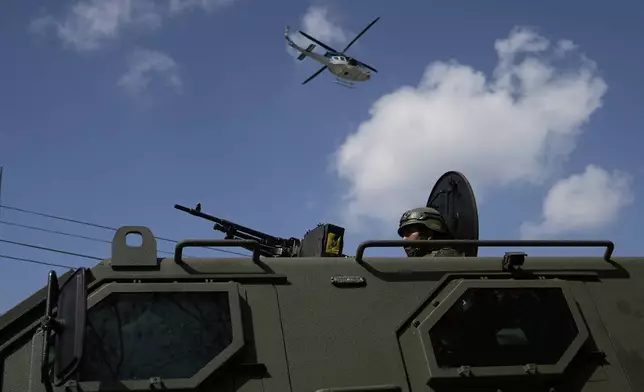 A soldier takes position in an armored vehicle outside the Preventivo Zona 18 prison during an operation to free guards taken hostage and retake control of the facility in Guatemala City, Sunday, Jan. 18, 2026. (AP Photo/Emmanuel Andres)