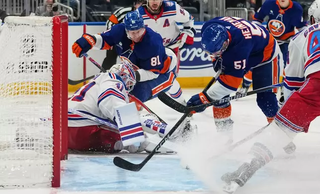 New York Rangers goaltender Spencer Martin (41)protects the net from New York Islanders' Emil Heineman (51) and Ondrej Palat (81) during the second period of an NHL hockey game Wednesday, Jan. 28, 2026, in Elmont, N.Y. (AP Photo/Frank Franklin II)