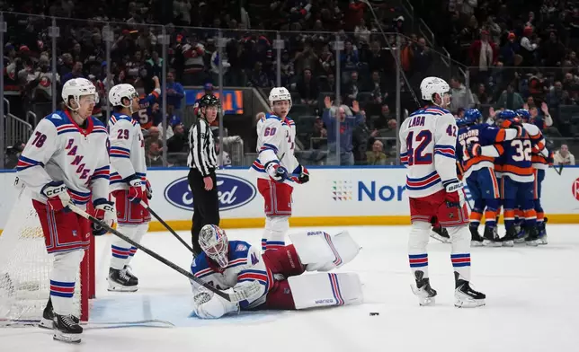 New York Rangers goaltender Spencer Martin, Brennan Othmann (78), Matthew Robertson (29), Scott Morrow (60) and Noah Laba (42) react as the New York Islanders celebrate a goal by Jean-Gabriel Pageau during the second period of an NHL hockey game Wednesday, Jan. 28, 2026, in Elmont, N.Y. (AP Photo/Frank Franklin II)