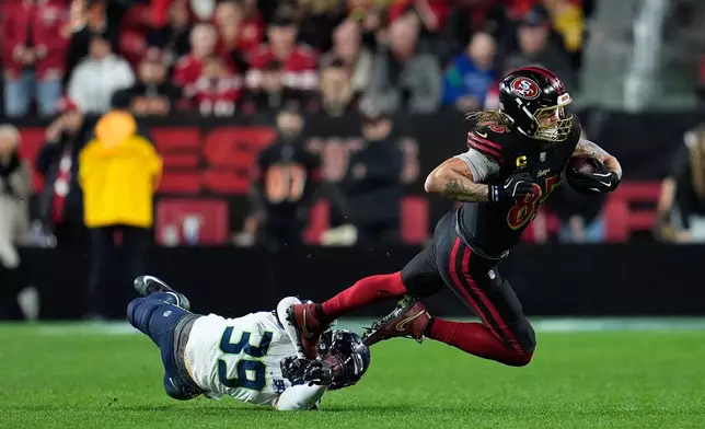 San Francisco 49ers tight end George Kittle, right, is tackled Seattle Seahawks safety Ty Okada (39) during the second half of an NFL football game in Santa Clara, Calif., Saturday, Jan. 3, 2026. (AP Photo/Godofredo A. Vásquez)