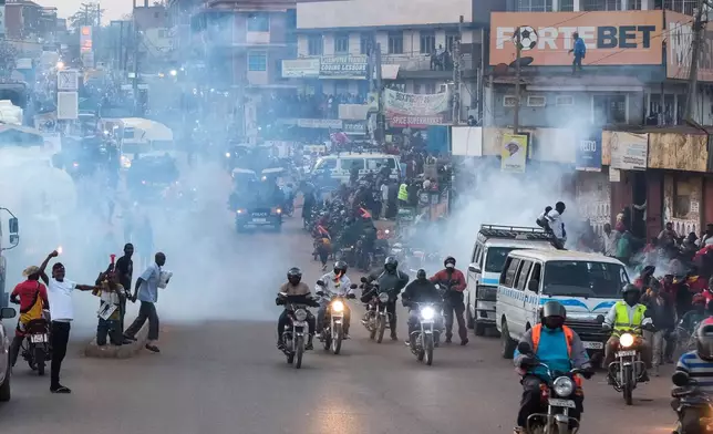 Supporters of Ugandan opposition presidential candidate Robert Kyagulanyi Ssentamu, who is known as Bobi Wine are tear-gassed by police during a campaign rally ahead of elections, in Mukono, Uganda, Friday, Jan. 9, 2026. (AP Photo/Hajarah Nalwadda)