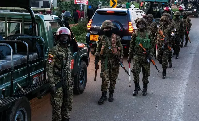 Ugandan security forces patrol a street during a campaign rally for opposition presidential candidate Robert Kyagulanyi Ssentamu who is known as Bobi Wine, ahead of elections, in Mukono, Uganda, Friday, Jan. 9, 2026. (AP Photo/Hajarah Nalwadda)