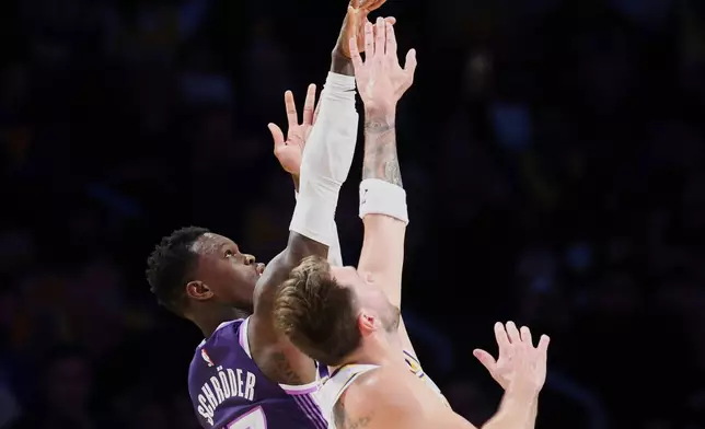 Sacramento Kings guard Dennis Schroder (17) shoots against Los Angeles Lakers guard Luka Doncic, front right, during the first half of an NBA basketball game, Sunday, Dec. 28, 2025, in Los Angeles. (AP Photo/Jessie Alcheh)
