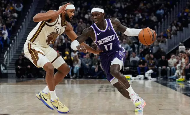Sacramento Kings guard Dennis Schröder, right, moves the ball while defended by Golden State Warriors guard Moses Moody during the first half of an NBA basketball game, Friday, Jan. 9, 2026, in San Francisco. (AP Photo/Godofredo A. Vásquez)