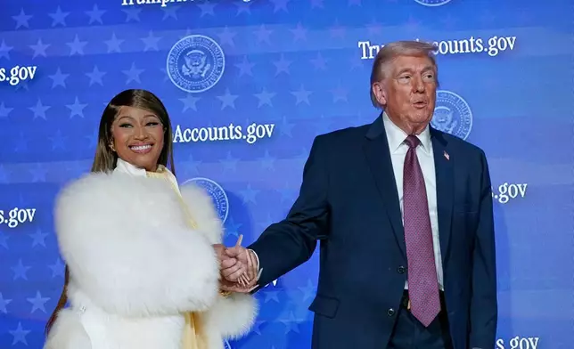 Nicki Minaj and President Donald Trump stand on stage together during an event for "Trump Accounts" at Carnegie Mellon Auditorium, Wednesday, Jan. 28, 2026, in Washington. (AP Photo/Jose Luis Magana)