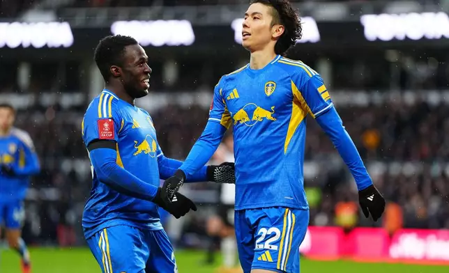 Leeds United's Ao Tanaka, right, celebrates with Wilfried Gnonto after scoring their side's second goal of the game during the Emirates FA Cup third round match between Derby County and Leeds United, in Derby, England, Sunday Jan. 11, 2026. (David Davies/PA via AP)