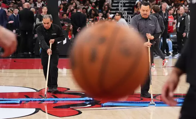 United center employees cleans the court during a delay before an NBA basketball game against the Miami Heat in Chicago, Thursday, Jan. 8, 2026. (AP Photo/Nam Y. Huh)