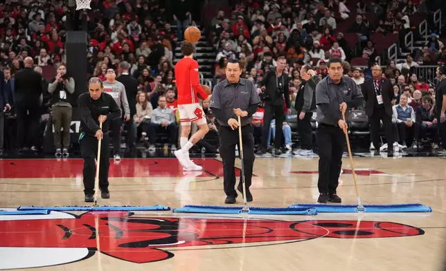 United center employees clean the court during a delay before an NBA basketball game against the Miami Heat in Chicago, Thursday, Jan. 8, 2026. (AP Photo/Nam Y. Huh)
