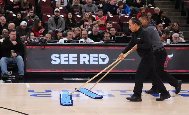 United center employees clean the court during a delay before an NBA basketball game against the Miami Heat in Chicago, Thursday, Jan. 8, 2026. (AP Photo/Nam Y. Huh)