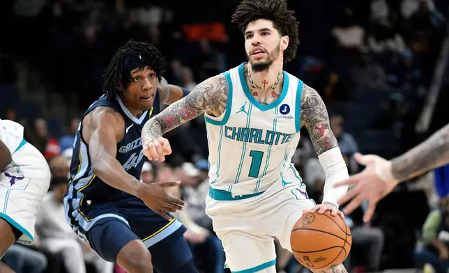 Charlotte Hornets guard LaMelo Ball (1) handles the ball ahead of Memphis Grizzlies forward GG Jackson II in the first half of an NBA basketball game, Wednesday, Jan. 28, 2026, in Memphis, Tenn. (AP Photo/Brandon Dill)
