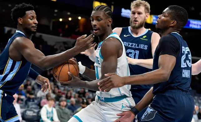 Charlotte Hornets forward Moussa Diabate (14) handles the ball between Memphis Grizzlies forward Jaren Jackson Jr., left, center Jock Landale (31), and forward Cedric Coward (23) in the first half of an NBA basketball game Wednesday, Jan. 28, 2026, in Memphis, Tenn. (AP Photo/Brandon Dill)