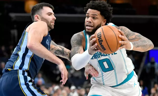 Charlotte Hornets forward Miles Bridges (0) handles the ball against Memphis Grizzlies guard John Konchar in the first half of an NBA basketball game, Wednesday, Jan. 28, 2026, in Memphis, Tenn. (AP Photo/Brandon Dill)
