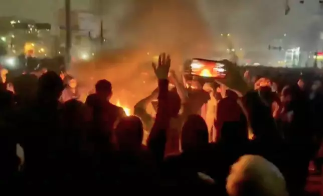 In this frame grab from footage circulating on social media shows protesters dancing and cheering around a bonfire as they take to the streets despite an intensifying crackdown as the Islamic Republic remains cut off from the rest of the world, in Tehran, Iran, Friday, Jan. 9, 2026.(UGC via AP)
