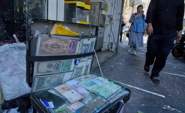 FILE - Current and pre-revolution Iranian banknotes are displayed by a street money exchanger at Ferdowsi square, Tehran's go-to venue for foreign currency exchange, in downtown Tehran, Iran, on Aug. 28, 2025. (AP Photo/Vahid Salemi, File)