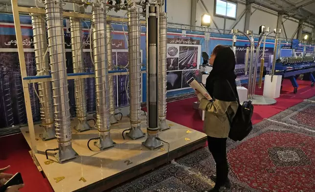 FILE -A student looks at Iran's domestically built centrifuges in an exhibition of the country's nuclear achievements, in Tehran, Iran, Wednesday, Feb. 8, 2023. (AP Photo/Vahid Salemi, File)